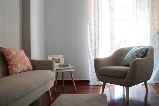 Two comfortable armchairs facing each other by a bright window, creating a welcoming space for conversation